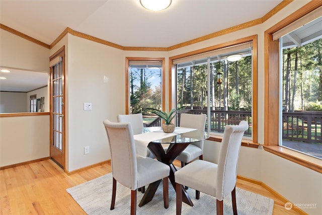 dining room featuring ornamental molding and light wood-type flooring