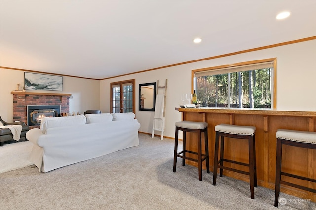 living room with light colored carpet, ornamental molding, and a brick fireplace