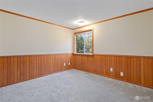 unfurnished room with light carpet, crown molding, and wooden walls