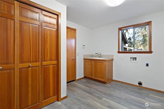 clothes washing area with sink, electric dryer hookup, cabinets, washer hookup, and light hardwood / wood-style floors