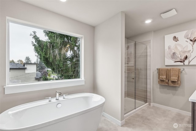 bathroom featuring independent shower and bath, a wealth of natural light, and vanity