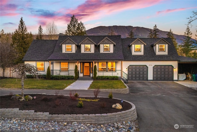 cape cod-style house featuring a porch, a garage, and a mountain view