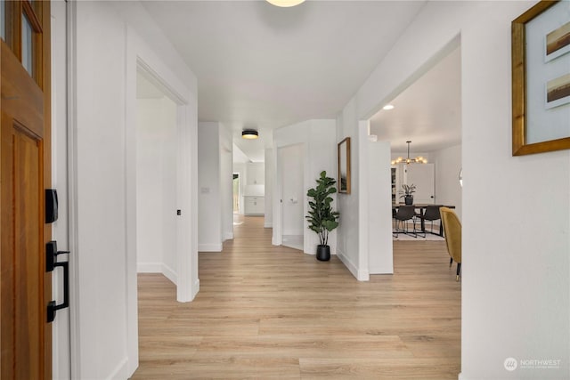 entryway with a notable chandelier and light wood-type flooring