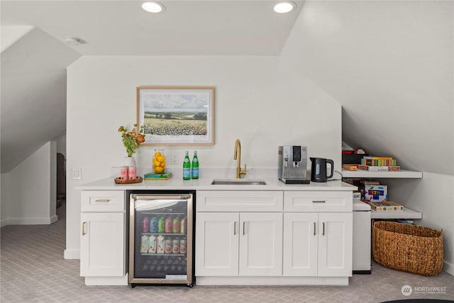 bar with sink, light colored carpet, beverage cooler, and white cabinets