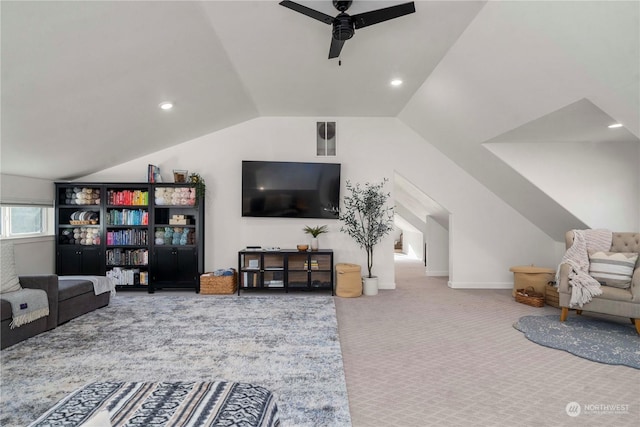 carpeted living room with ceiling fan and vaulted ceiling