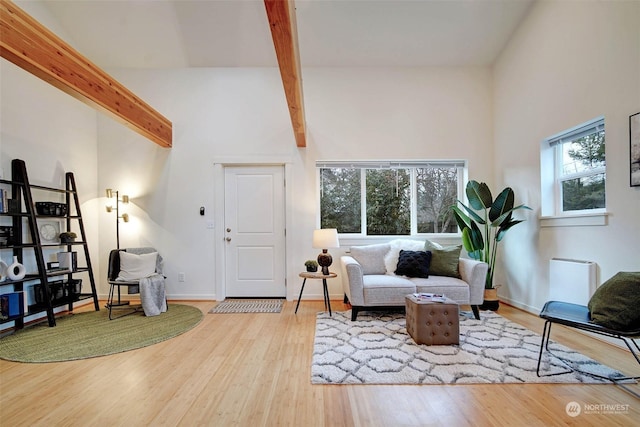 living area with hardwood / wood-style floors and beam ceiling