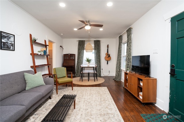 living room with ceiling fan and dark wood-type flooring