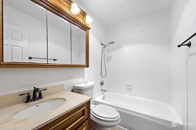 full bathroom with vanity, tiled shower / bath, and toilet