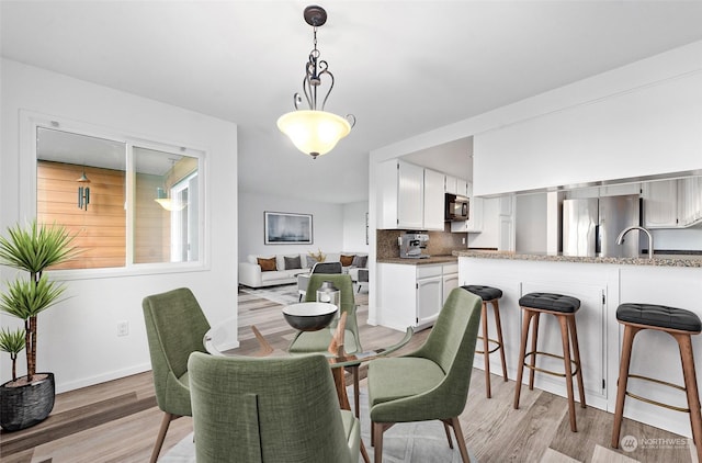 dining area featuring sink and light wood-type flooring