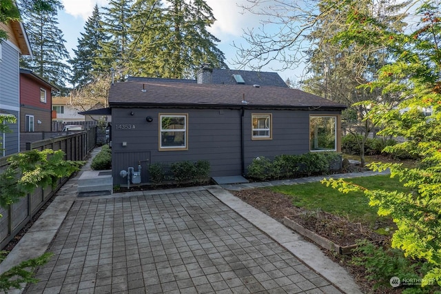 back of property with a yard and a patio