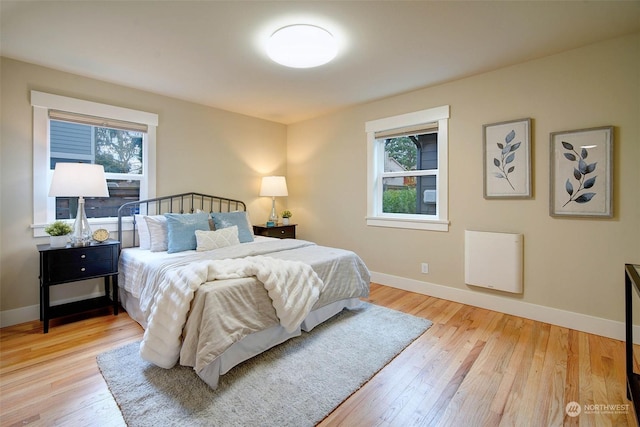 bedroom with multiple windows and light wood-type flooring