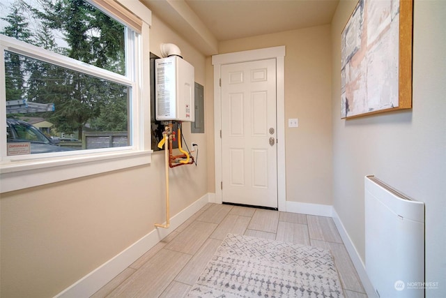 doorway to outside with tankless water heater and electric panel