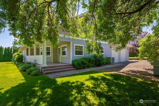 view of front of property with a porch, a garage, and a front lawn