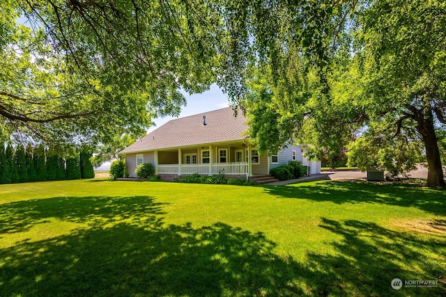 rear view of property featuring a lawn and covered porch