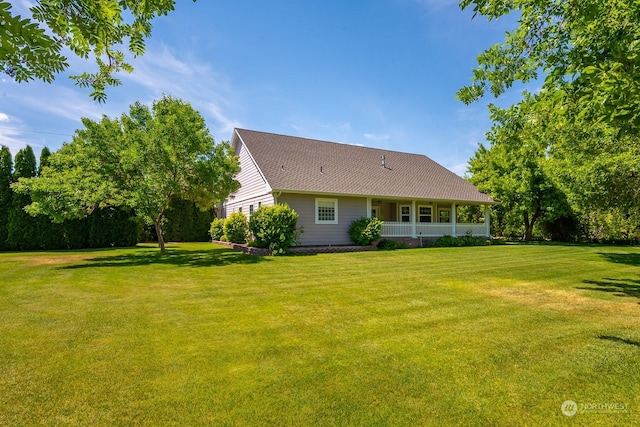 back of house with a porch and a yard