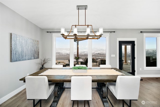 dining room featuring a mountain view, a chandelier, and wood-type flooring