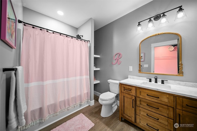 full bathroom with shower / bathtub combination with curtain, hardwood / wood-style flooring, vanity, and toilet