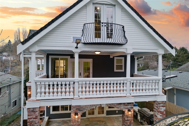 back house at dusk with a balcony