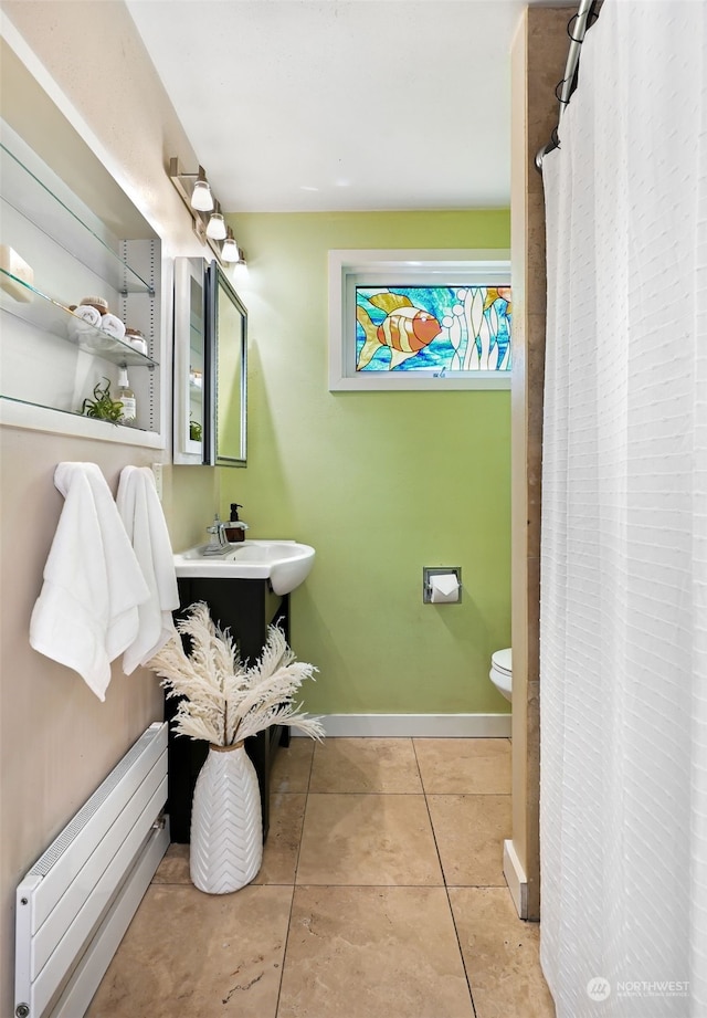 bathroom featuring sink, toilet, tile patterned flooring, and a baseboard heating unit