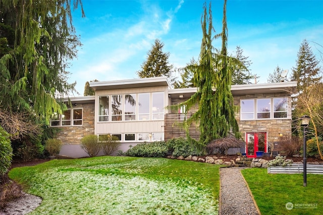 view of front of property with a sunroom and a front lawn