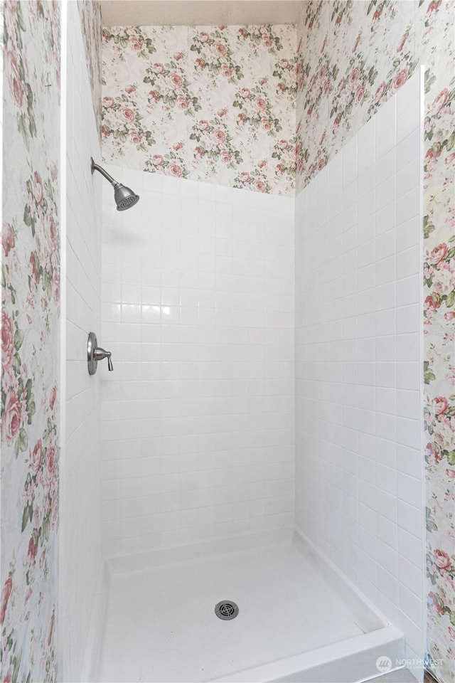 bathroom featuring wallpapered walls and a stall shower