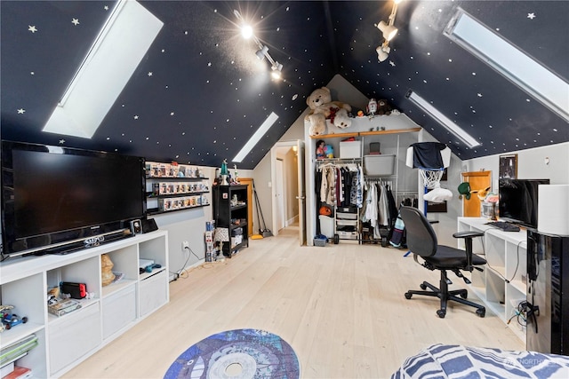 bedroom featuring vaulted ceiling with skylight and wood finished floors