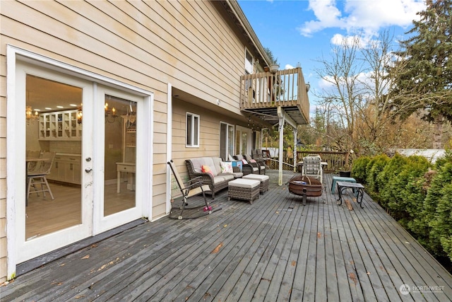 deck with an outdoor living space with a fire pit