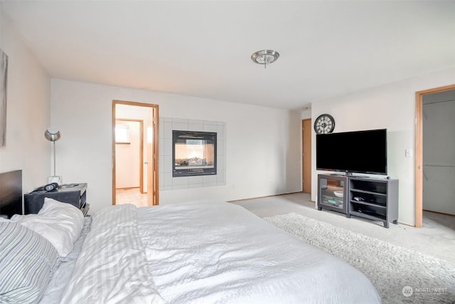 carpeted bedroom featuring a fireplace