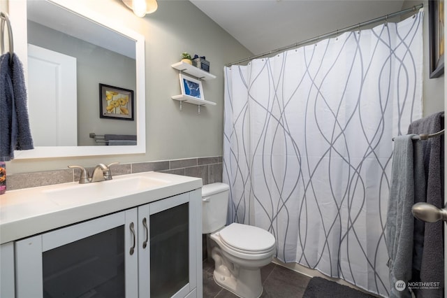 bathroom featuring tile walls, vanity, and toilet