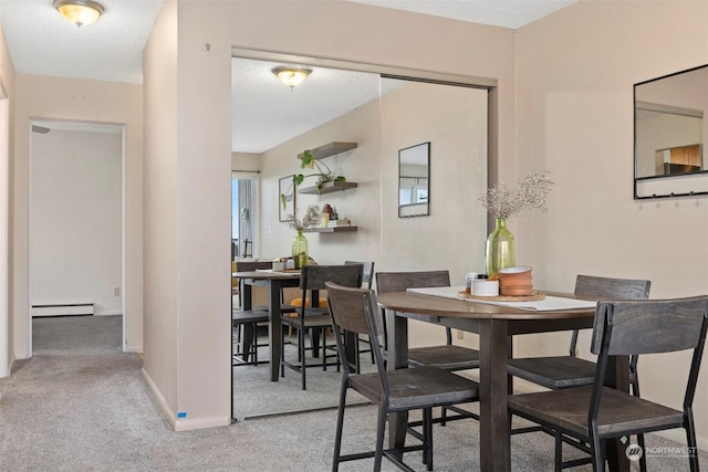 dining room with baseboard heating, carpet flooring, and a textured ceiling