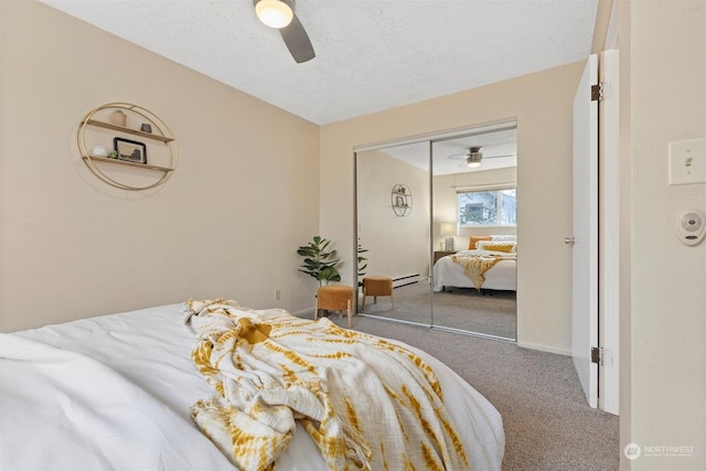 carpeted bedroom with ceiling fan, a closet, and a textured ceiling