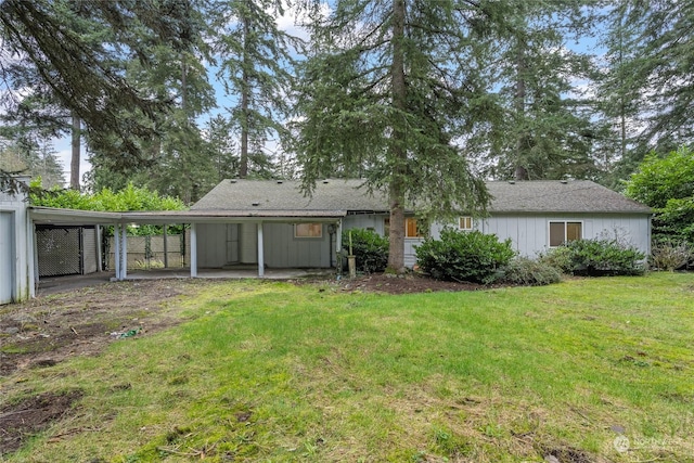 rear view of property with a carport and a lawn