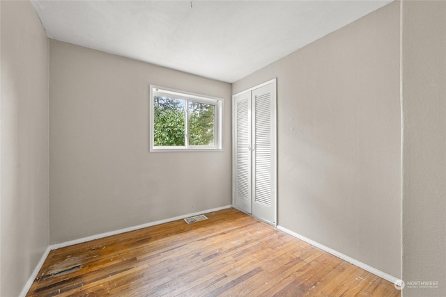 unfurnished bedroom featuring a closet and hardwood / wood-style flooring