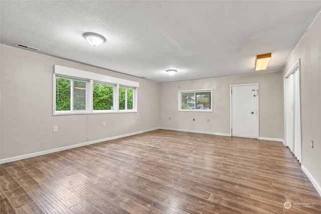 spare room featuring a textured ceiling and hardwood / wood-style flooring