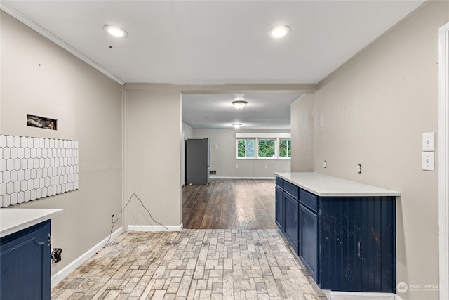 kitchen featuring hardwood / wood-style flooring, stainless steel fridge, blue cabinets, and ornamental molding