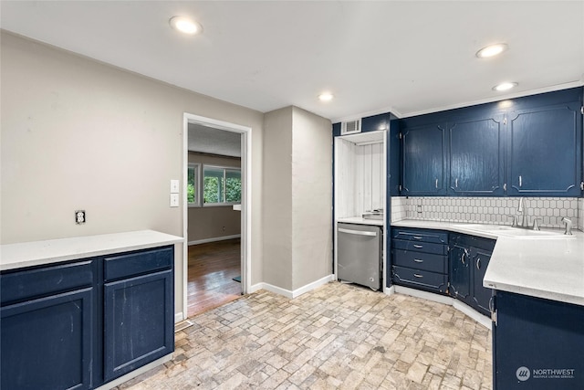 kitchen featuring tasteful backsplash, blue cabinets, stainless steel dishwasher, and sink