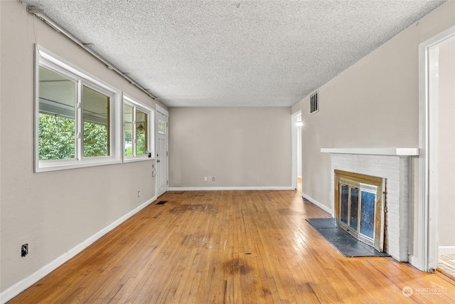 unfurnished living room featuring hardwood / wood-style floors and a textured ceiling