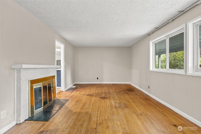 unfurnished living room with hardwood / wood-style floors and a textured ceiling