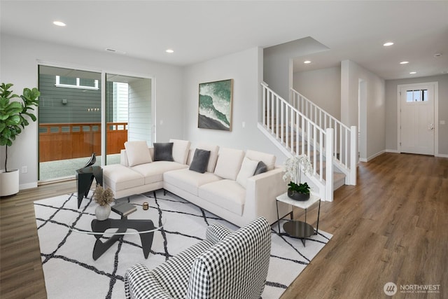 living room featuring recessed lighting, stairway, a healthy amount of sunlight, and wood finished floors