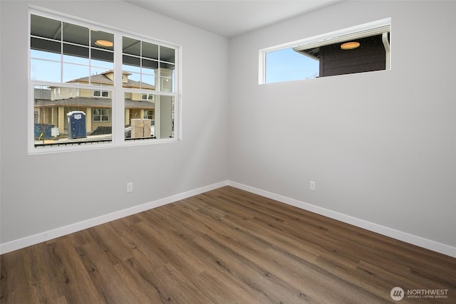 empty room featuring baseboards and wood finished floors