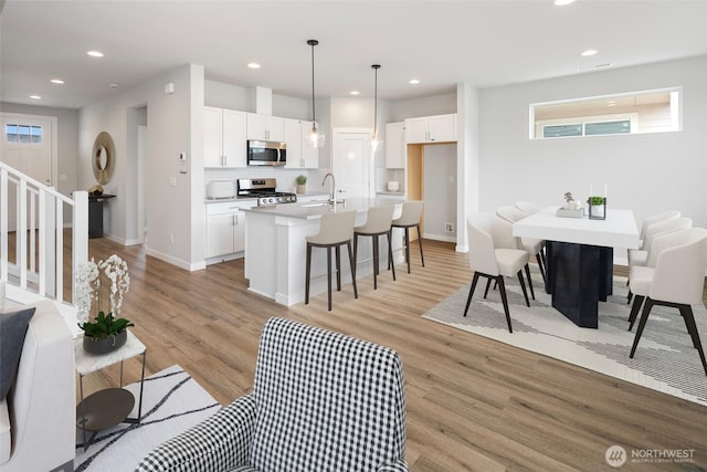 living room with light wood finished floors, stairway, recessed lighting, and baseboards