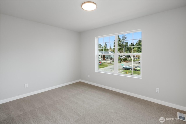 carpeted empty room with visible vents and baseboards