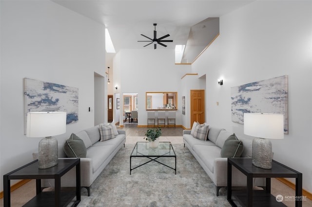 living room with a towering ceiling and ceiling fan