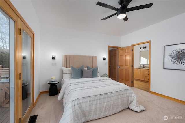 bedroom featuring sink, ensuite bathroom, ceiling fan, and light colored carpet