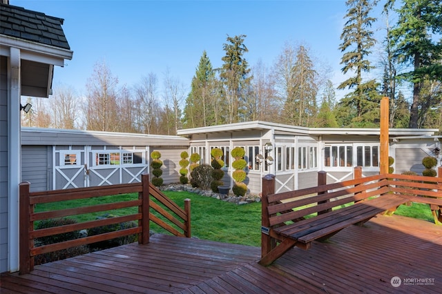 wooden terrace with an outdoor structure and a lawn