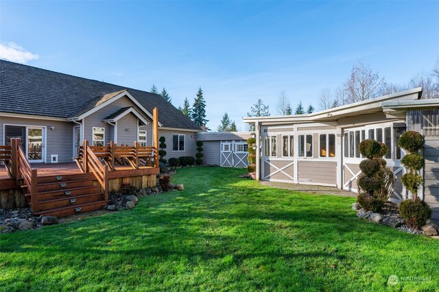 view of yard with a deck, a sunroom, and a storage shed