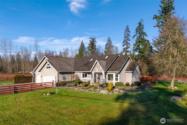 view of front of house featuring an attached garage, fence, and a front yard