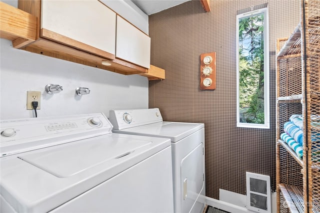 laundry room featuring washer and dryer and cabinets