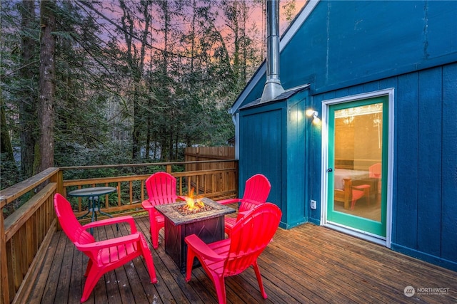 deck at dusk featuring an outdoor fire pit