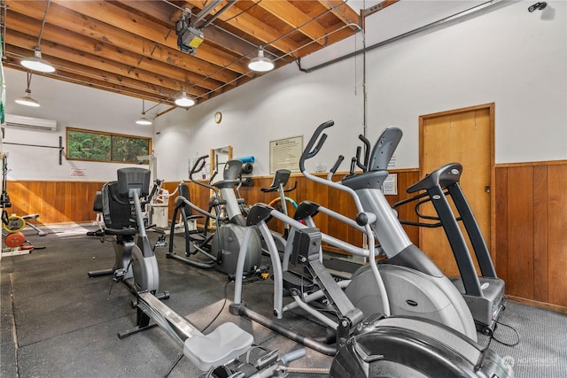 exercise room featuring a wall mounted AC and wood walls